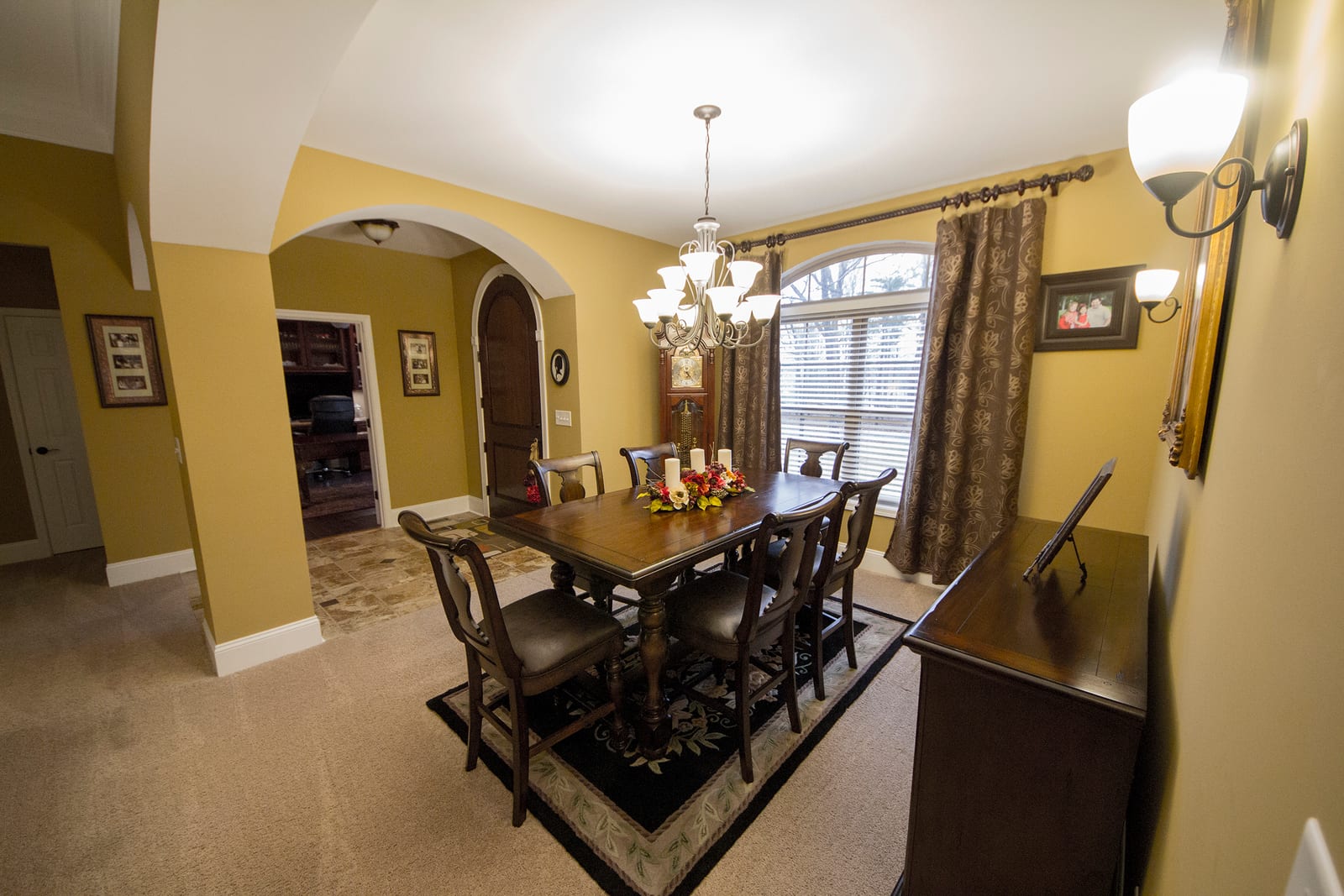 Dining room design with arched openings and custom lighting