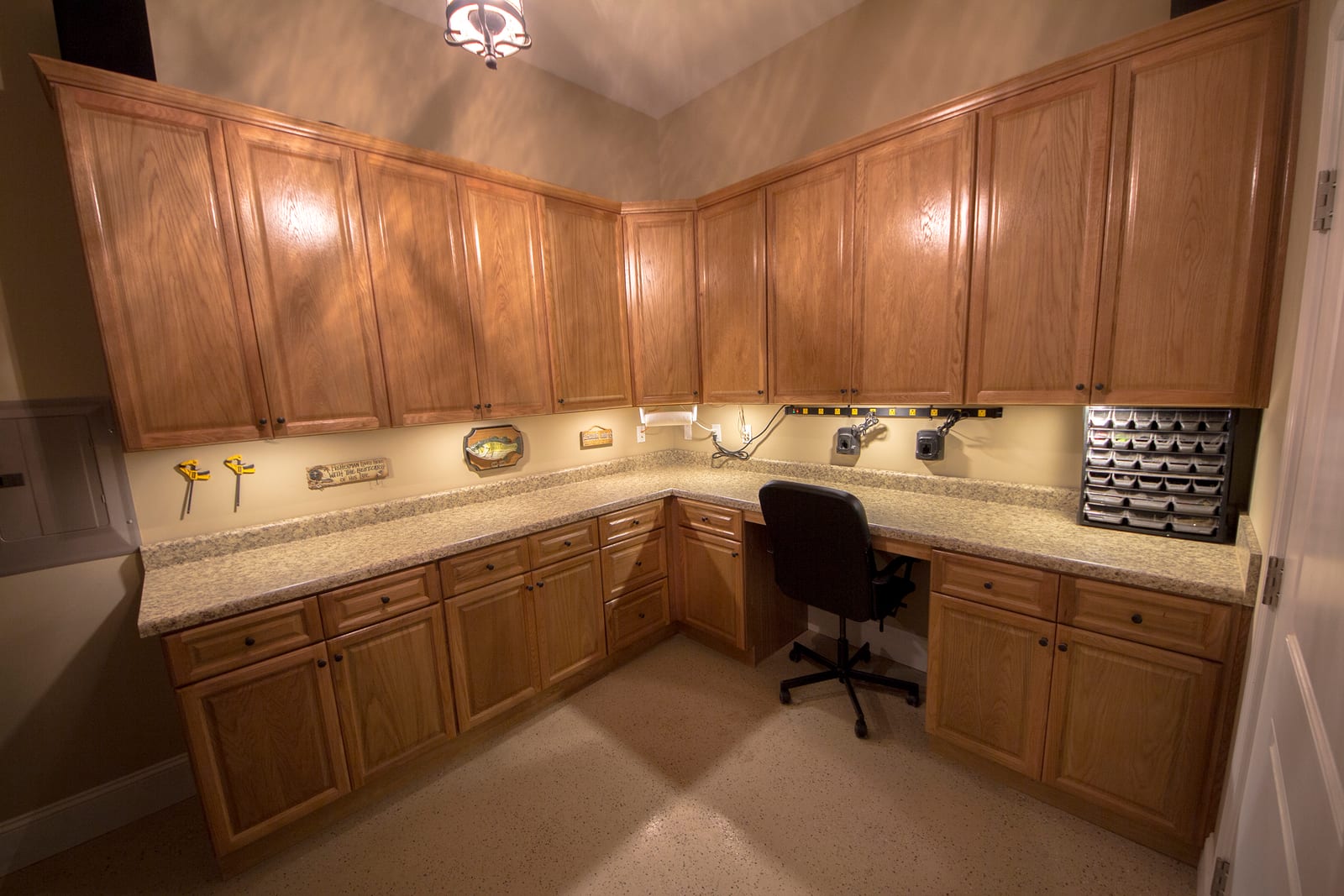 Home workshop design with wraparound cabinetry and counters